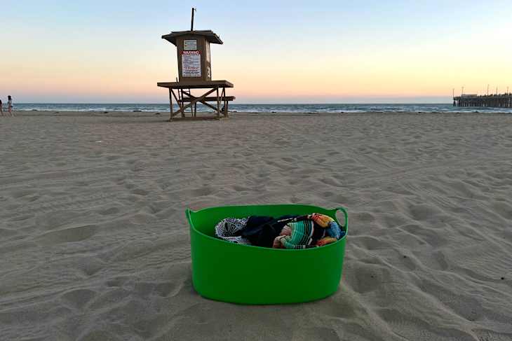 IKEA TORKIS basket full of beach supplies on the beach at sunset