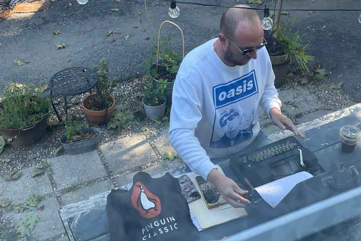 Someone using a vintage typewriter outside.