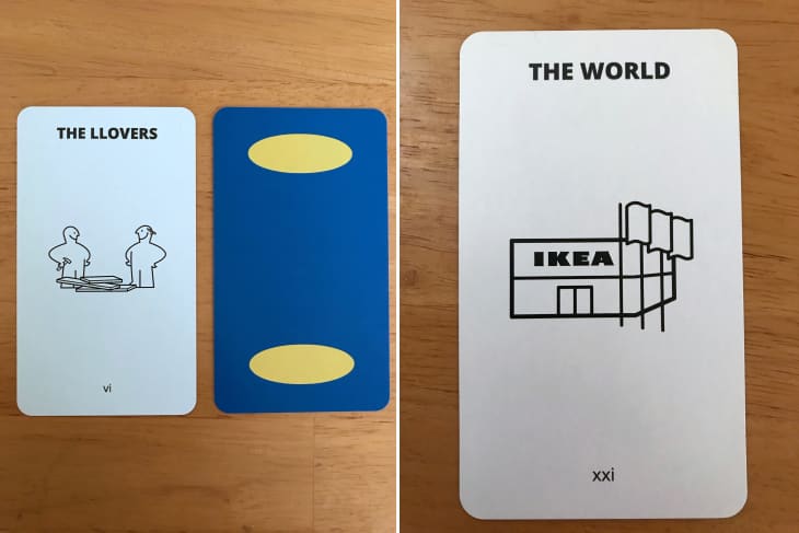 Three tarot cards on a wooden table: "The Llover," a blue card with yellow ovals, and "The World" with an IKEA illustration.