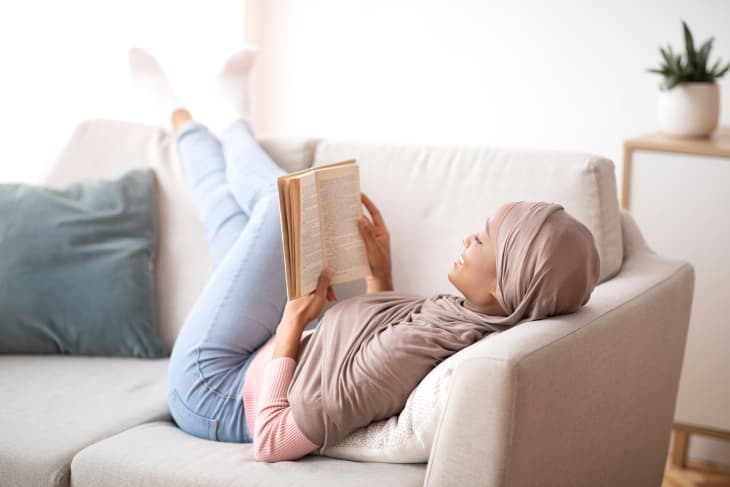 Black woman wearing hijab reading a book.