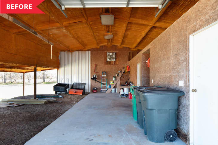 Open garage with wooden ceiling, storage shelves, trash bins, and tools.