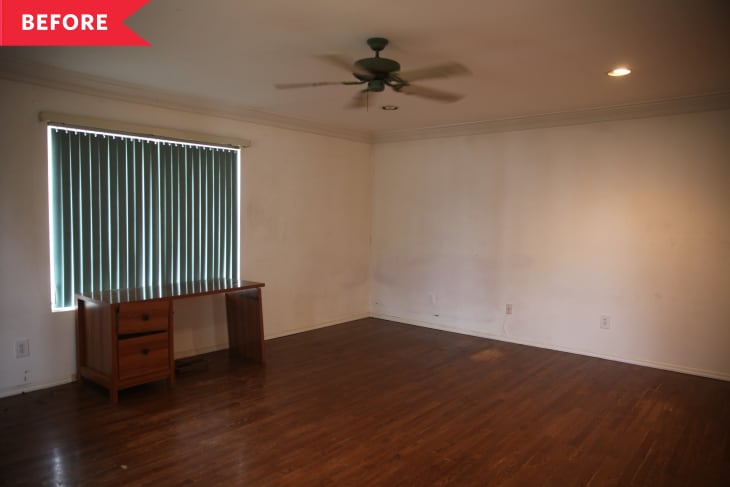 Empty room with wooden floor, ceiling fan, window blinds, and a small wooden desk with drawers.