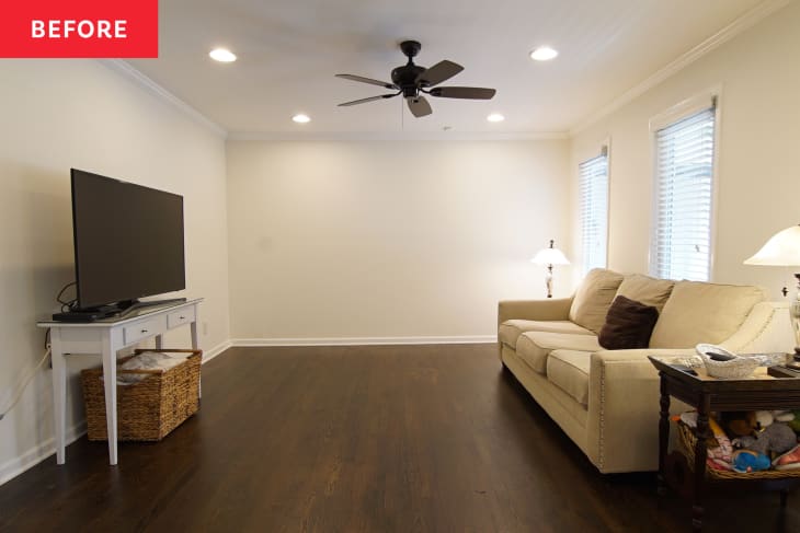 Living room with beige sofa, dark wood floor, TV on white stand, and ceiling fan.