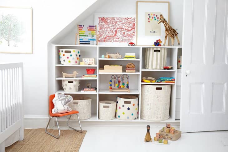 white kids' room with built in shelves with a variety of Pehr fabric storage bins