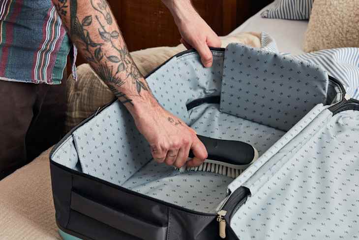 shot of someone cleaning the inside of a suitcase