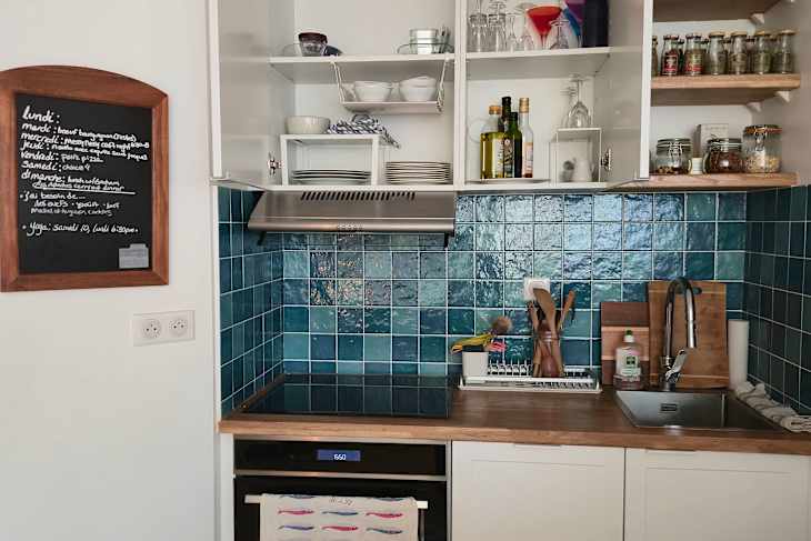 Aqua colored tile backsplash in newly organized kitchen.