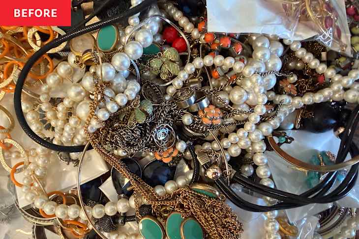 A tangled assortment of jewelry including pearl necklaces, colorful earrings, and metal chains.