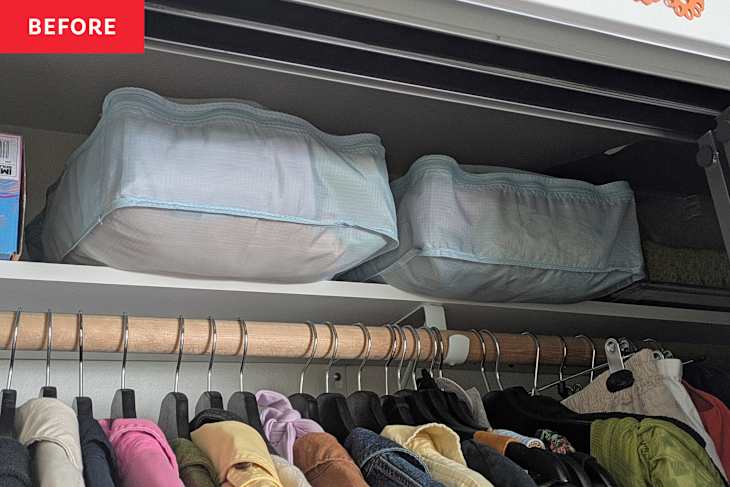 Storage bins on a shelf above a wooden clothing rod with various hanging garments in a closet.