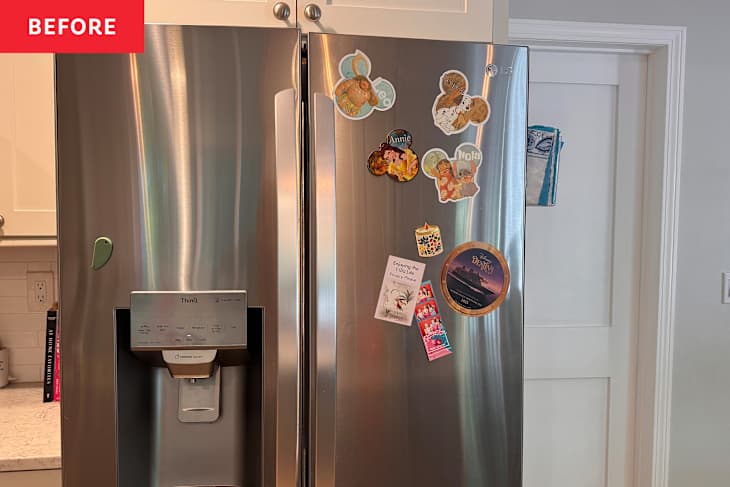 Stainless steel refrigerator with various colorful magnets and a water dispenser, set in a kitchen.
