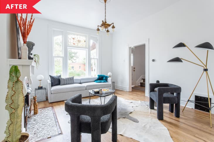 After: Living room with modern furniture, fresh coat of white paint, and big window with stained glass at the top