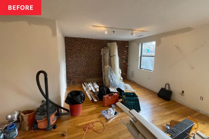 Empty living room before home staging: some rolled up rugs, power tools, etc