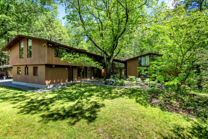 angled roof, wood slates, narrow rectangle window, green grass, trees