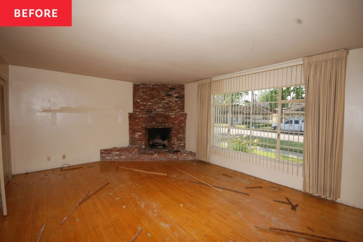 Empty living room with brick fireplace before home staging