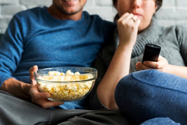 couple watching tv with popcorn