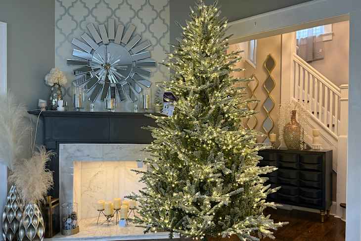 duchess christmas tree lit up in front of fireplace