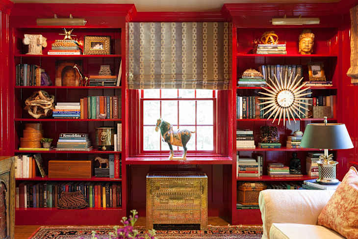 Living room with focus on floor-to-ceiling wall of red bookshelves