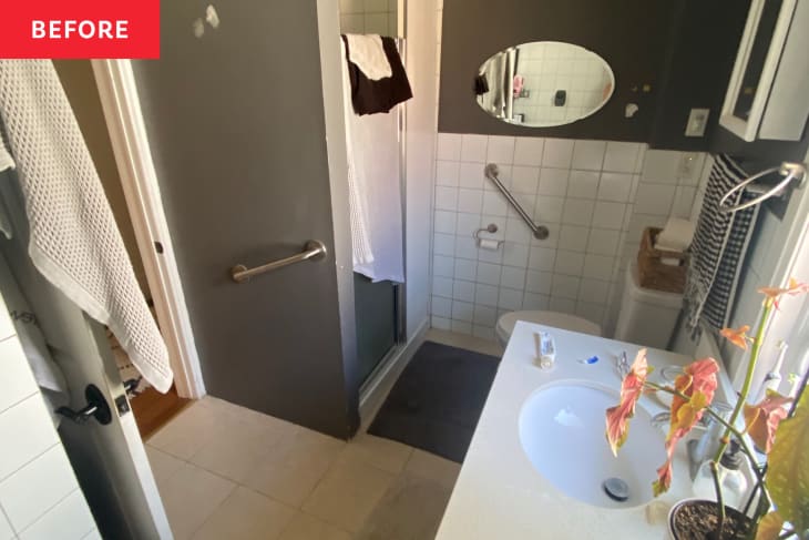 Grey painted bathroom with light colored tiles. before renovation.