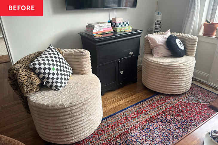 Two round, plush chairs with textured fabric, a black cabinet with books and decor, and a colorful area rug.