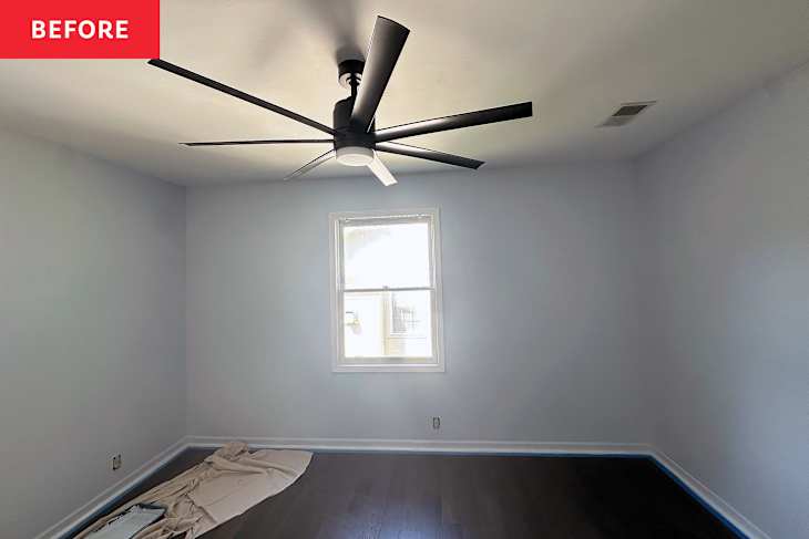 Empty room with light blue walls, dark hardwood floor, a ceiling fan, and a window with natural light. A drop cloth is on the floor.