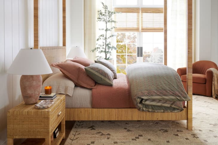 Bedroom with wood poster bed, Cala Rattan Nightstand, warm and neutral colored textiles, all Pottery Barn