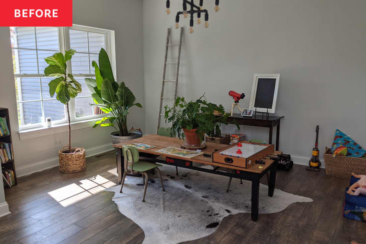 Children's playroom with small work desk in center and toys all around the room.
