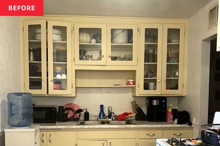 Light neutral cabinets and marble countertop with microwave and coffeemaker in kitchen.