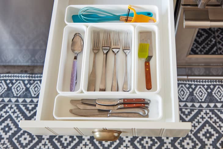 A drawer divider keeps spoons, forks, bread knives, and other daily kitchen tools organized