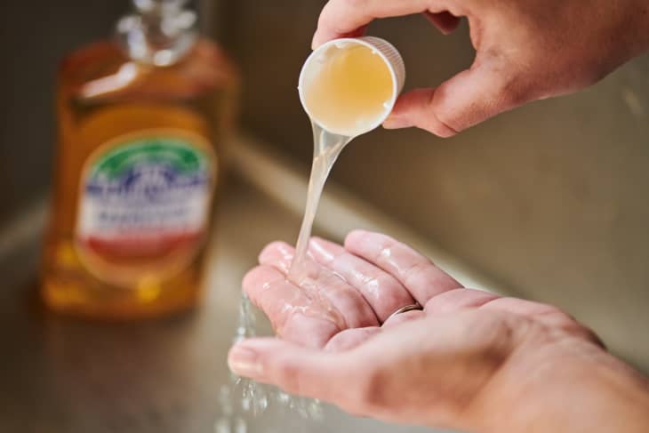 Pouring cupful of mouthwash onto hand