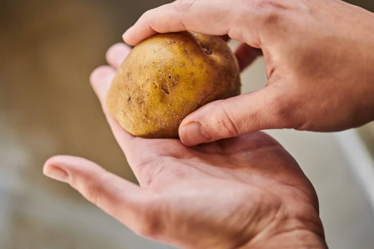 Rubbing half of a potato onto hand