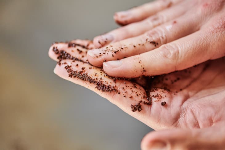 Rubbing coffee grounds into damp hands