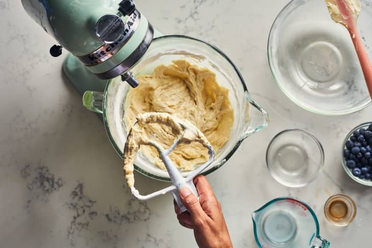 somone pulling the attachment to a kitchenaid out of dough