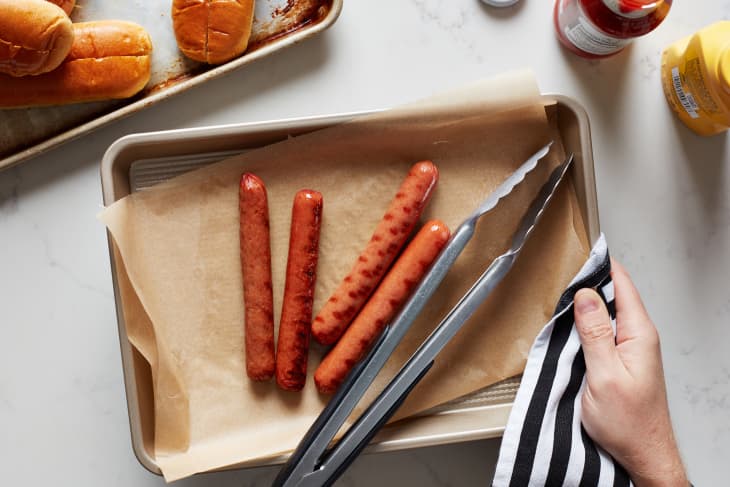 Hot dogs on in wax lined sheet pan prepped for the grill.