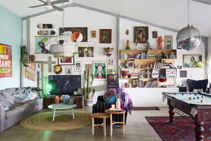 Eclectic living room with colorful decor, wall art, bookshelves, a pool table, and a large disco ball.