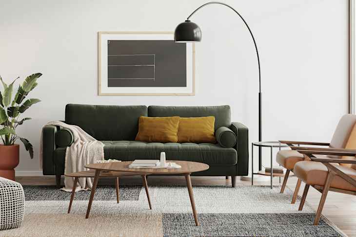 Cozy living room featuring a green sofa with yellow pillows, a wooden coffee table, and modern armchairs.