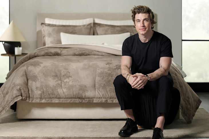 Jeremiah Brent in front of a bed made with his duvet set