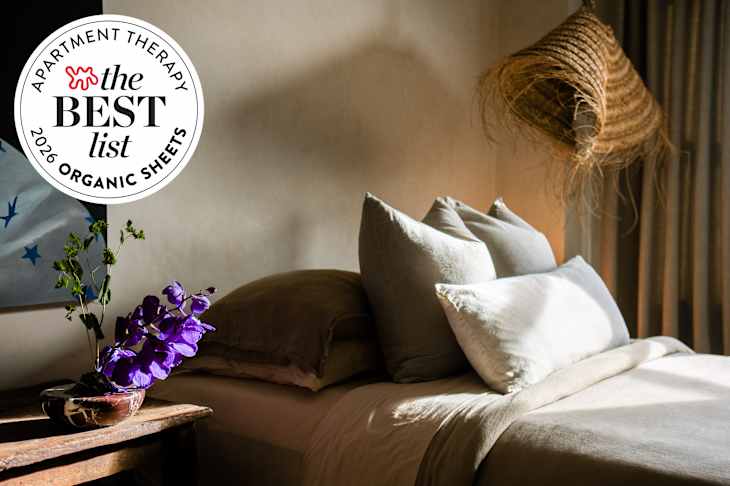 serene beige bedroom with neutral hues and straw/rattan pendant lamp. AT best list seal in upper left