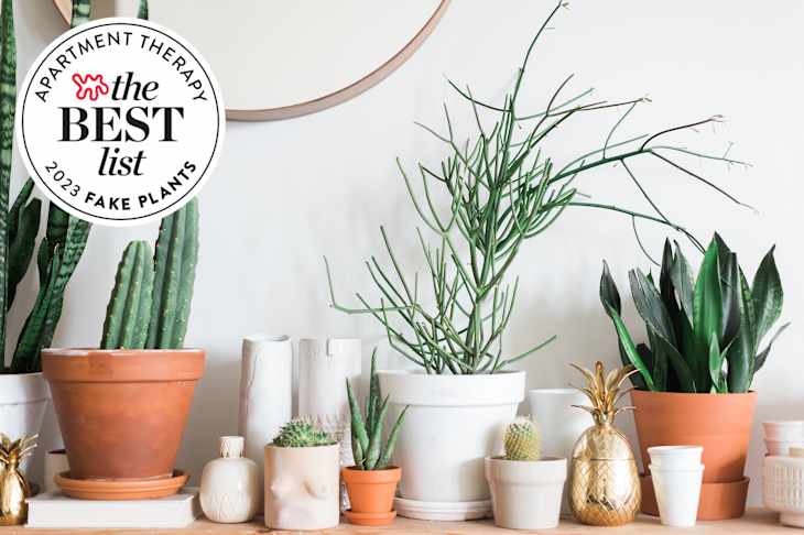 Shelf full of many kinds of fake plants in terra cotta and white pots. Seal in upper left says "Apartment Therapy the Best List 2023 Fake Plants"