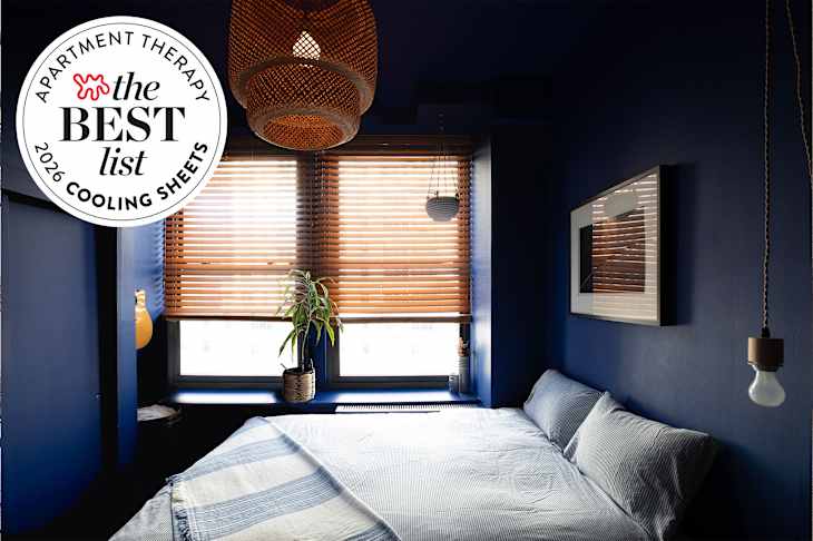 Dark blue bedroom and bed with cool toned linens with best list seal in upper leg