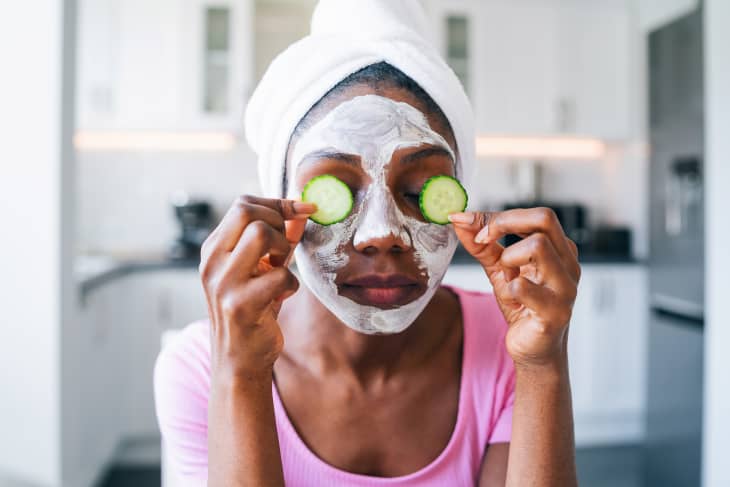 Beautiful young woman with cucumber on eyes