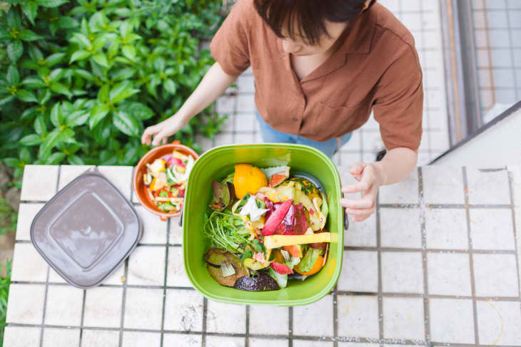 Woman putting food garbage into compost bin