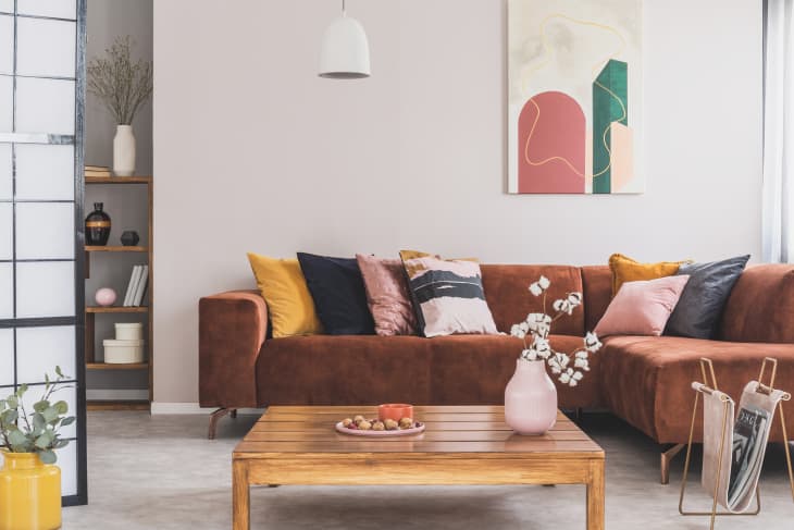 Living room with rust-colored suede sofa, wood coffee table