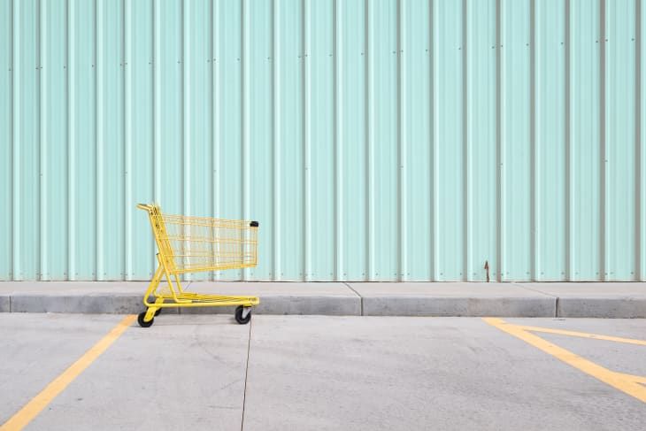 Yellow Shopping Cart On Footpath Against Wall