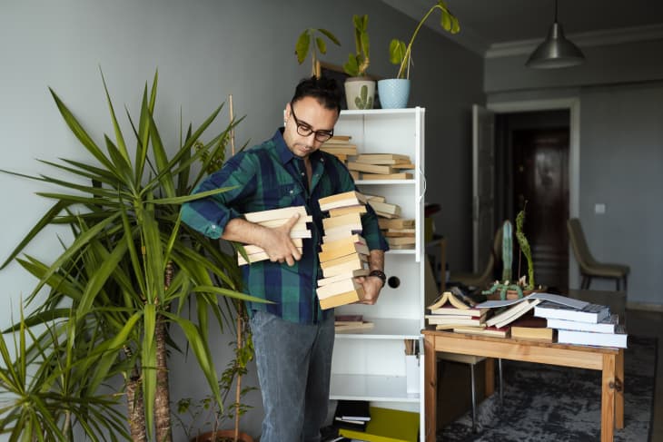 Millennial man organizing his book collections