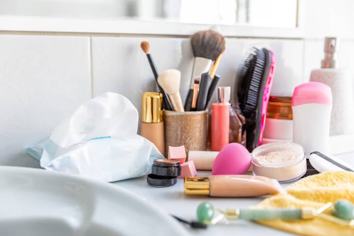messy vanity with makeup brushes, makeup wipes, and clutter