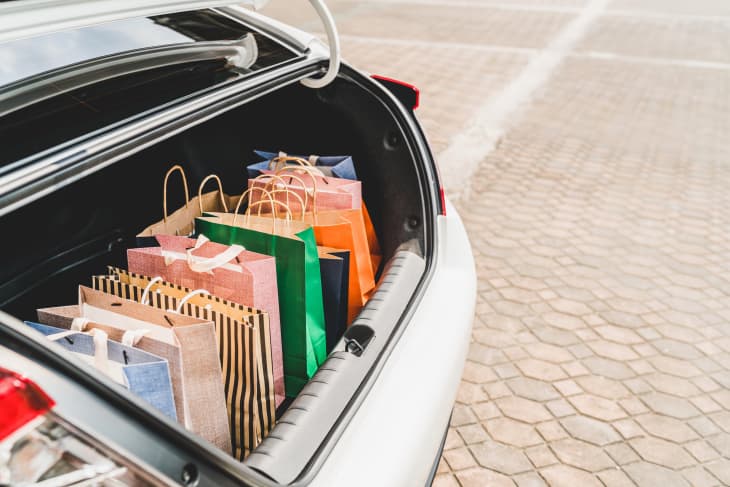 Car trunk full of colorful gift bags in parking lot