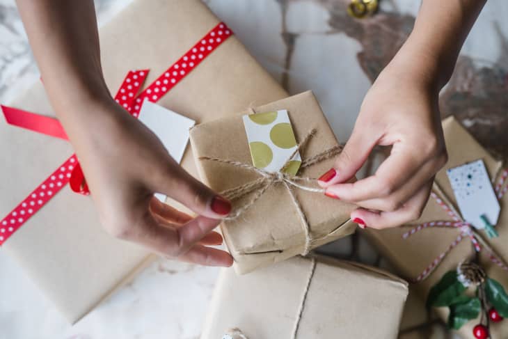 Hands tying the bow on a Christmas present