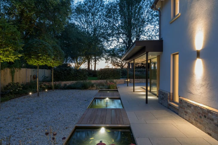 Exterior of a modern house and garden illuminated at night.