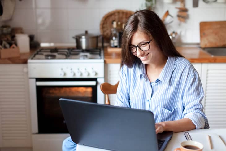 Woman working on laptop in kitchen