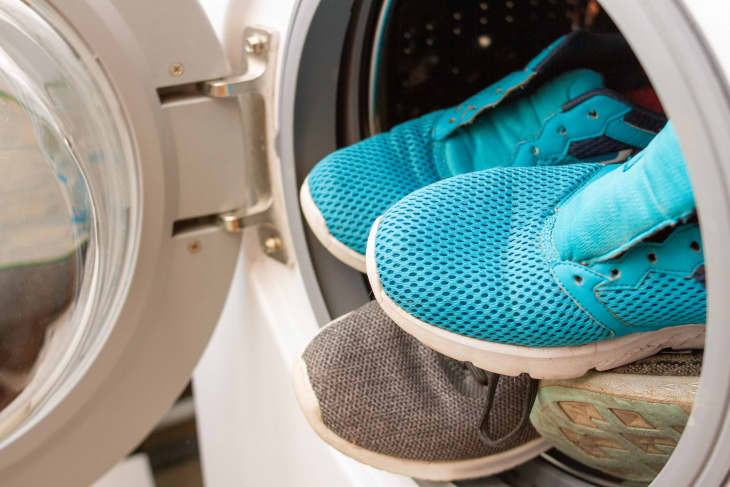 Pair of sneakers in washing machine, closeup.