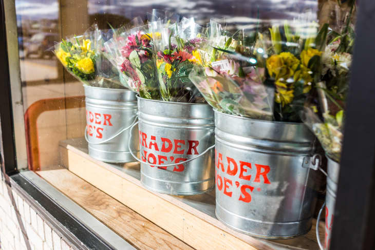 Buckets of flowers with Trader Joe's signs viewed from outside of store